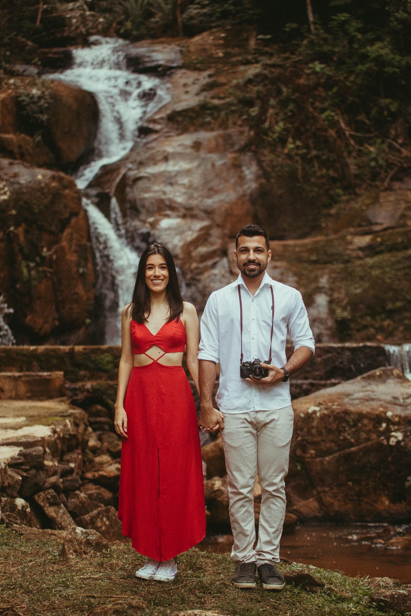 Budget 2 semaines de voyage en Chine Couple holding hands by a waterfall, capturing a romantic moment in nature.