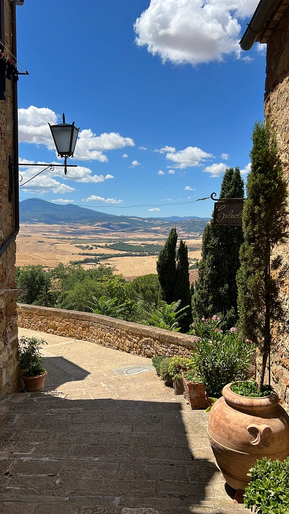 Pienza Val d'orcia Toscane Italie petite ruelle et vue dégagée sur les champs jaunes