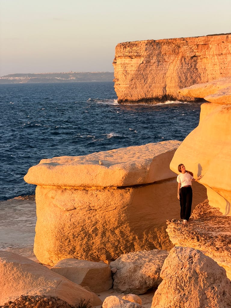 Blata tal-Melħ, le bout du monde à Malte au coucher de soleil avec voyageuse sur roches lissées